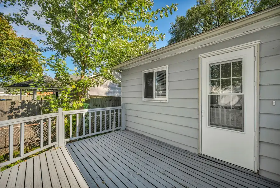 Painted wooden deck and railing along the back of a house