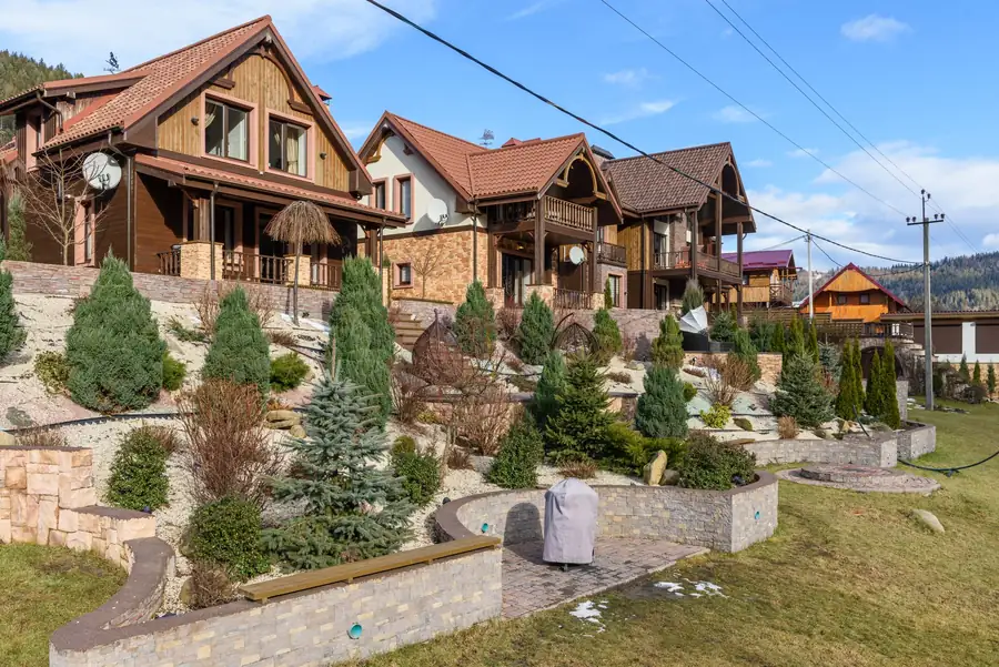 Landscaped front yard with evergreens and stone beds