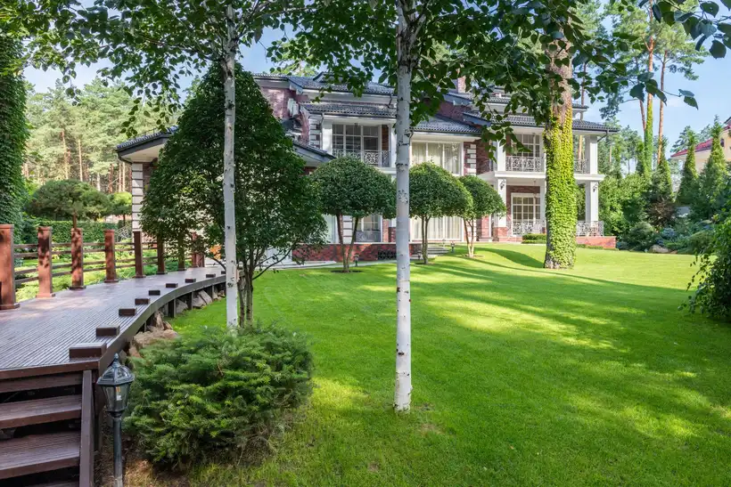 Landscaped yard with lawn, young trees and shrubs